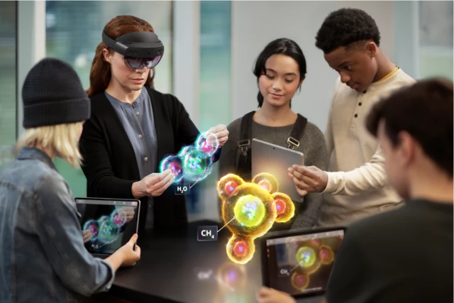 Instructor wearing a HoloLens, holding and visualizing a holographic H2O molecule. Four students visualizing that molecule and a holographic CH4 molecule through three mobile tablets.