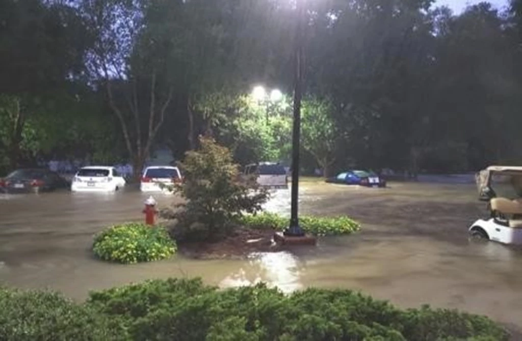 Town of Cary parking lot during a flood. Several cars parked in three-foot high flood water.