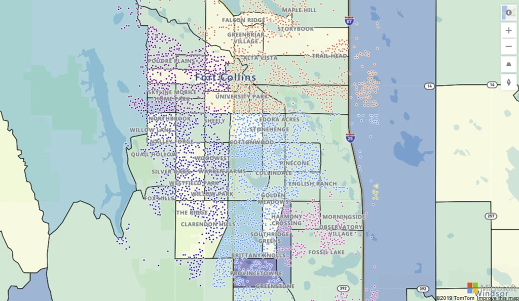 Map with a GeoJSON file of census tract boundaries, colored by population, below a layer of addresses colored by real estate value. 