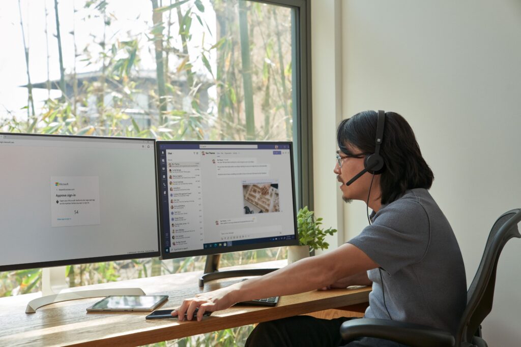 a person sitting at a desk in front of a window