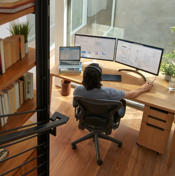 developer working from home at multi-screen desk setup