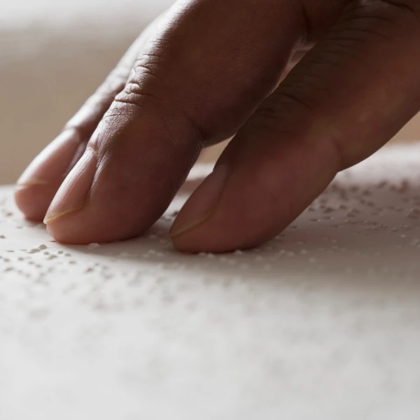 a close up of a hand reading braille