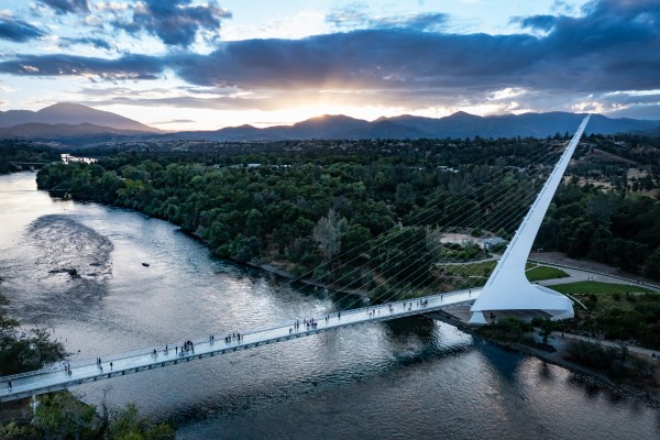 a bridge over a body of water with a mountain in the background