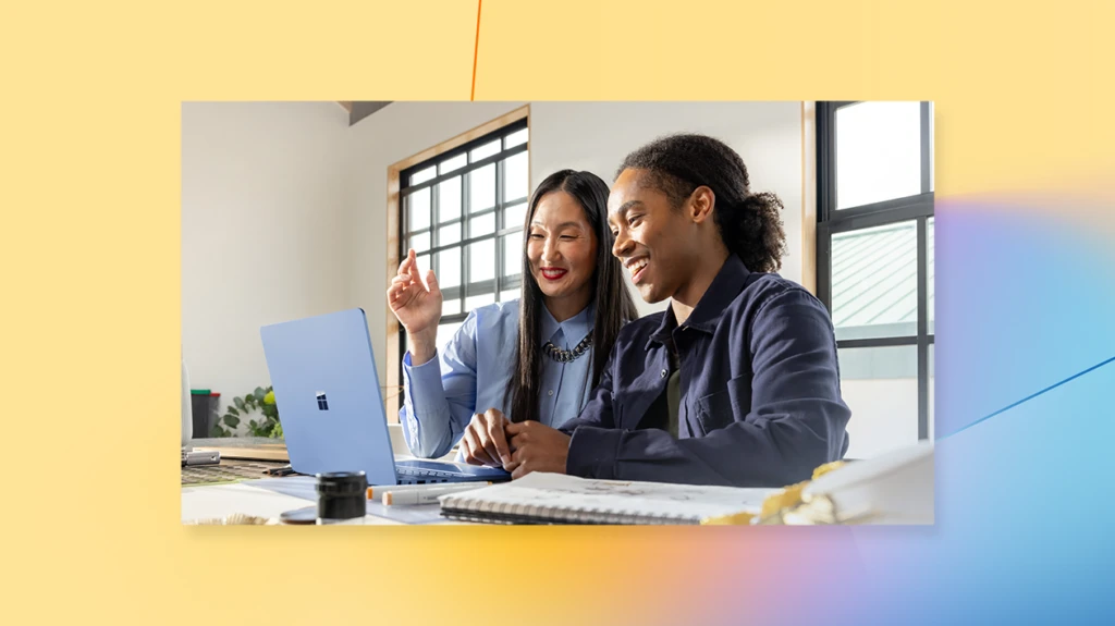 Two people smiling at a laptop