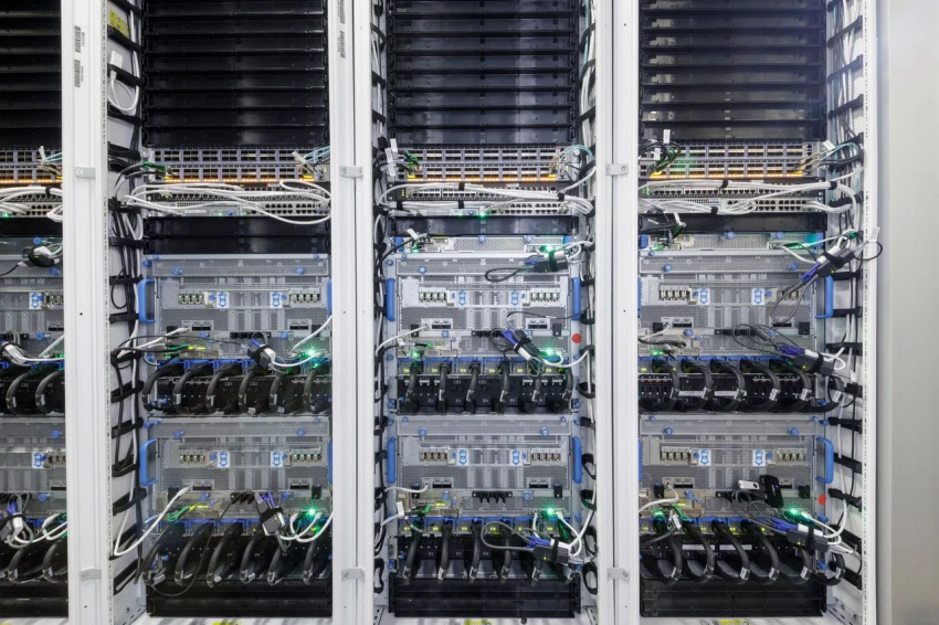 Datacenter close up of cold aisle rack, wires and multiple racks.
