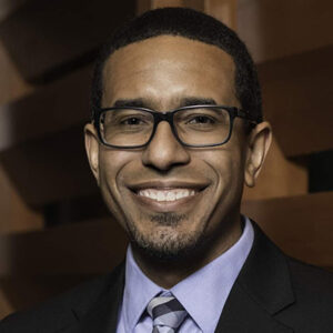 A man wearing glasses and a suit