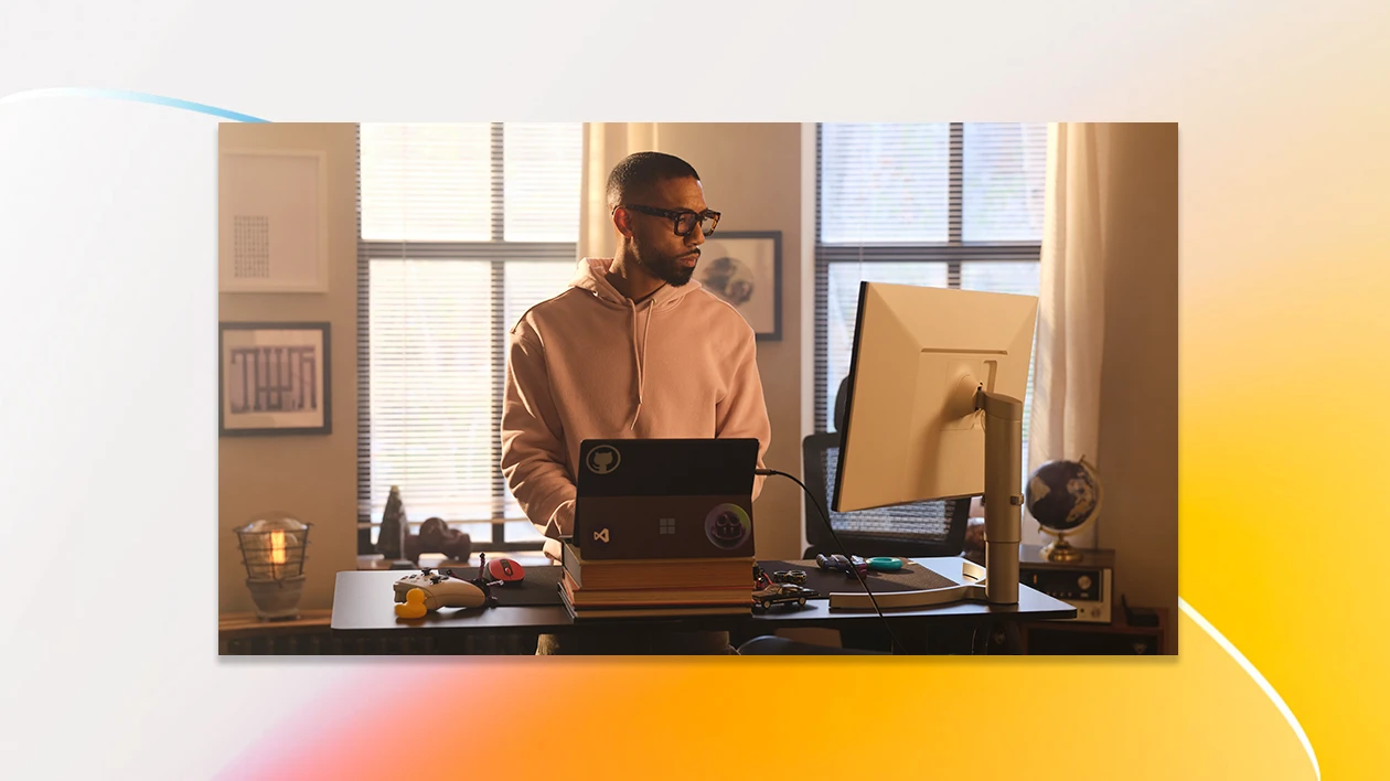 A man in a hoodie looking at a computer