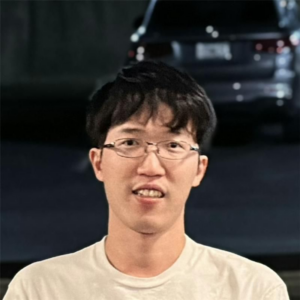 A man with glasses and a car in the background