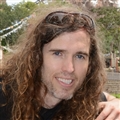A man with long hair and sunglasses on his head