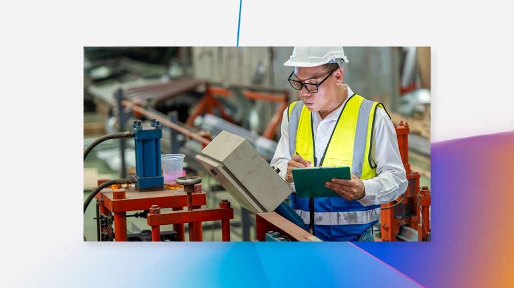 Engineer uses a digital tablet as he inspects machinery in a factory.