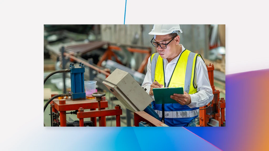 Engineer uses a digital tablet as he inspects machinery in a factory.