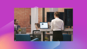 A woman works at a computer in an office.