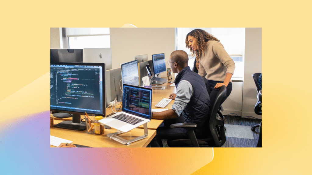Two employees gather around a computer.