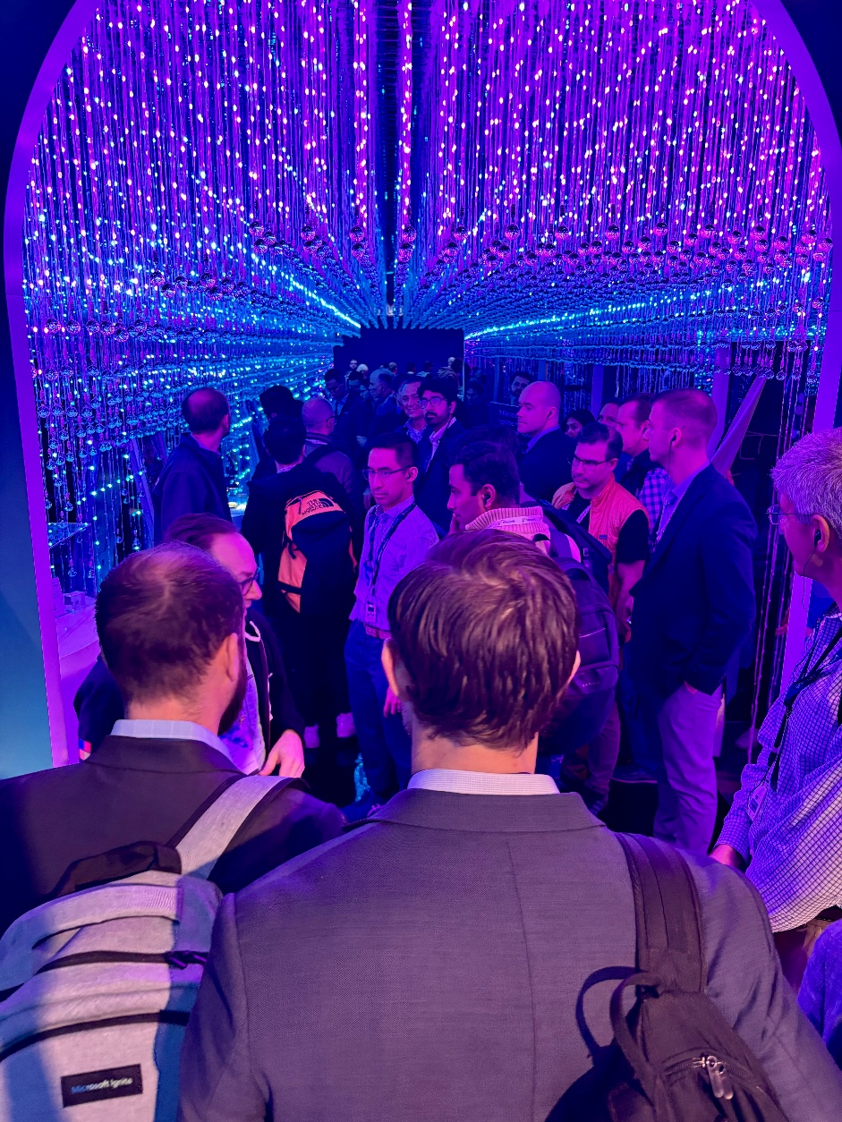A group of people in a tunnel with purple lights.