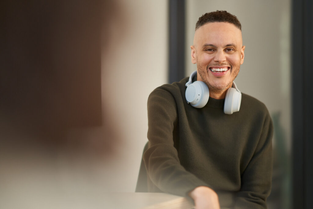 Person with headphones, smiling.