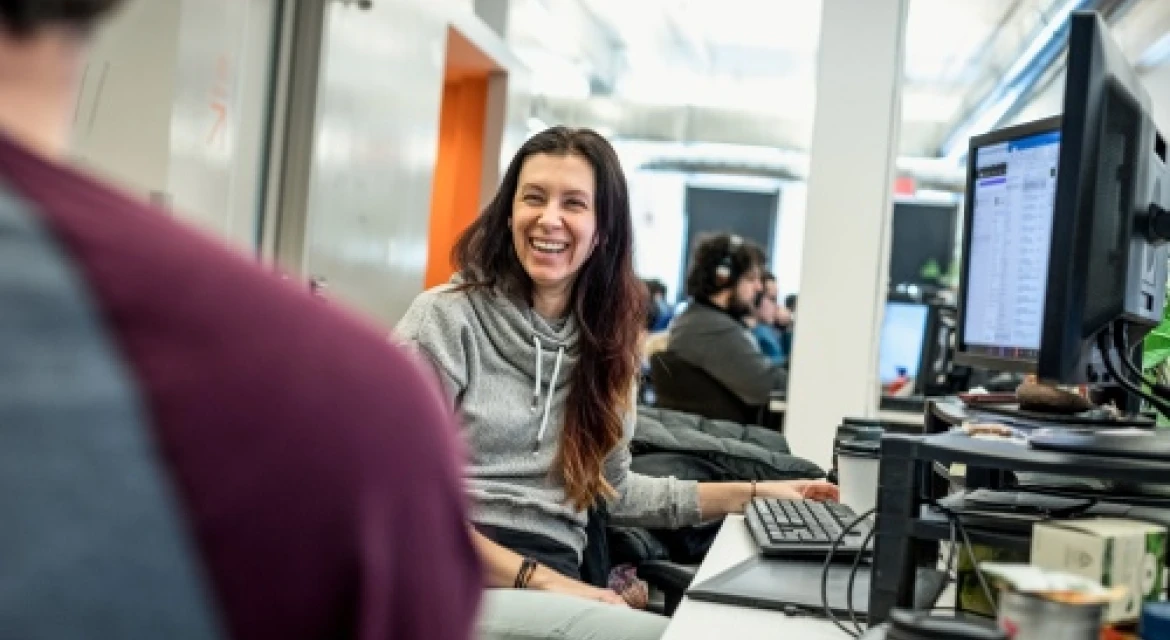 A woman smiles at coworker in an office.