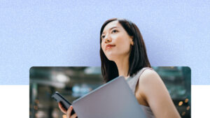 Person holding a laptop and smartphone, looking upward outdoors, with a softly blurred urban background and a blue textured graphic overlay above.