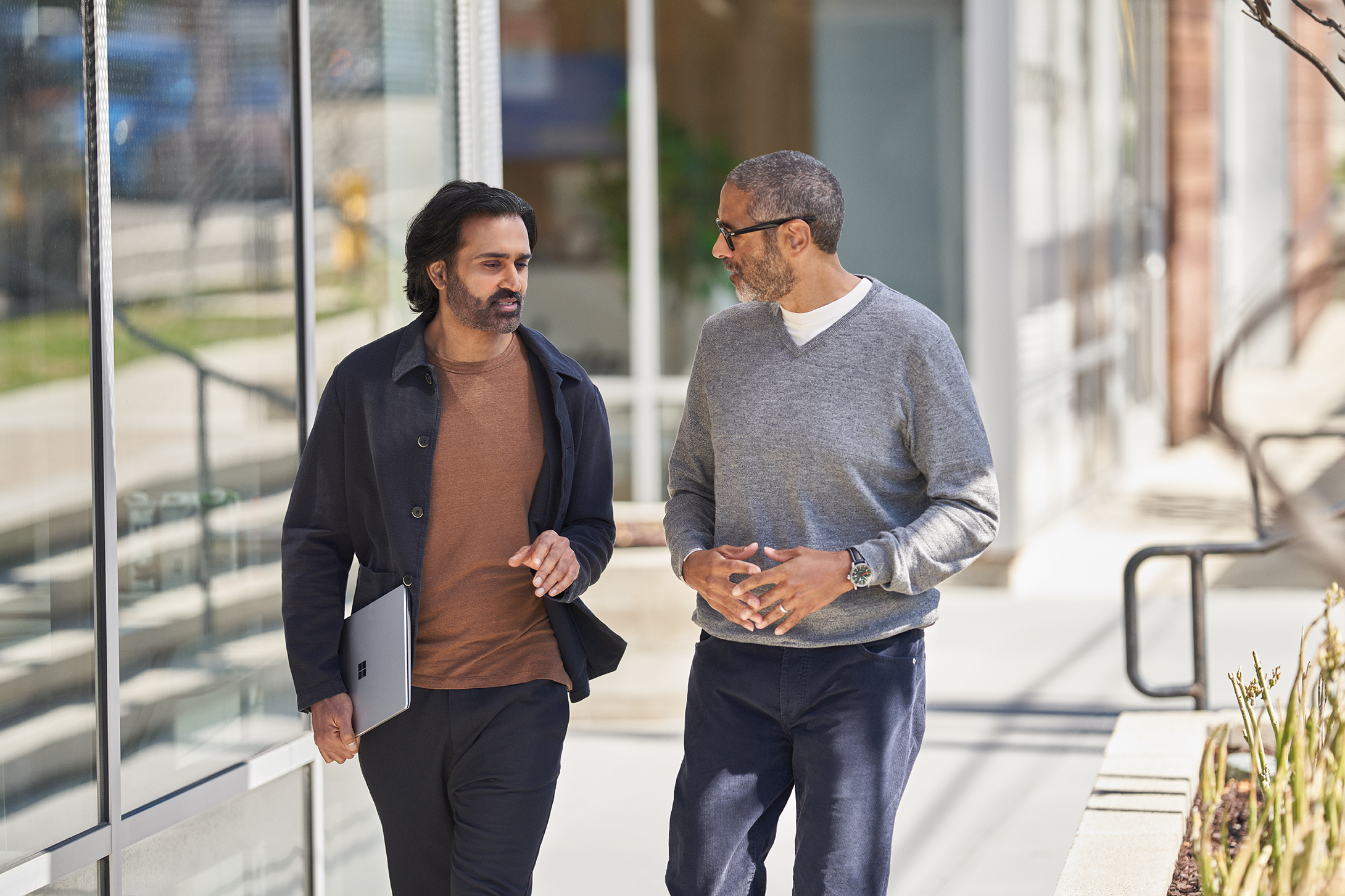 Two people having a conversation while walking outside.