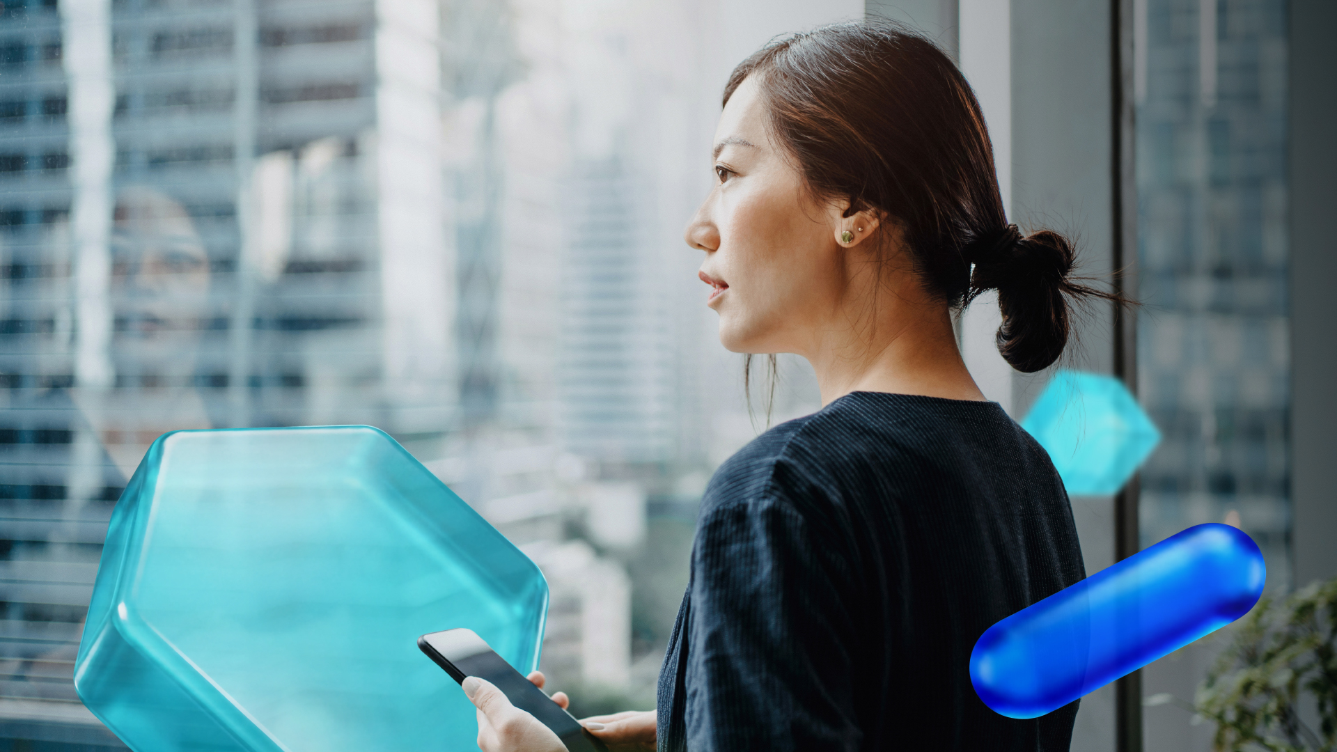 Person looking out near window, holding phone