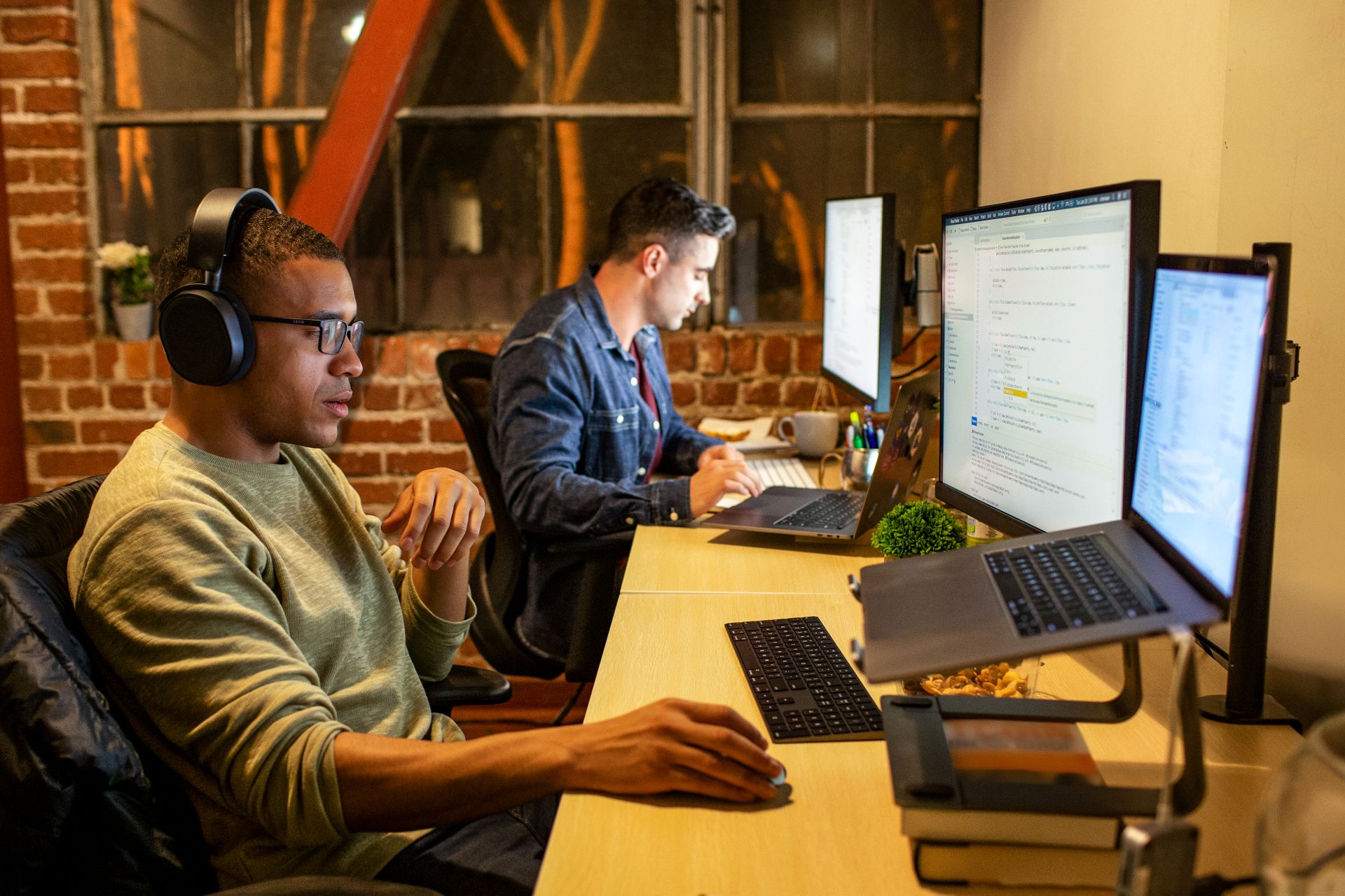Two people sitting at the desks and working at computers.